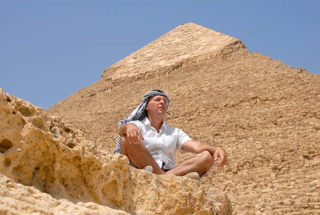 Человек отдыхает на фоне пирамиды в Египте